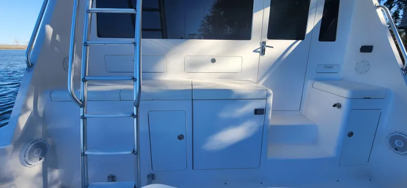 Slide: The Image of 2004 Cabo 48 Convertible yacht deck with ladder and storage compartments. - 5