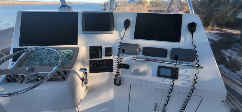 Slide: The Image of Helm of 2004 Cabo 48 Convertible yacht with navigation screens and controls. - 6