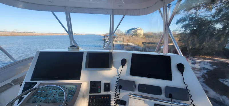 Slide: The Image of Helm of 2004 Cabo 48 Convertible yacht with navigation screens and river view. - 7