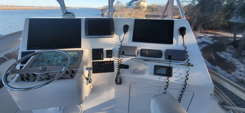 Slide: The Image of 2004 Cabo 48 Convertible yacht helm with navigation screens and controls. - 8