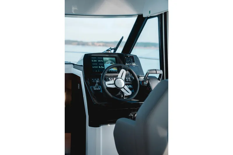 Slide: The Image of 2027 Beneteau Antares 9 V2 helm with modern navigation controls and steering wheel. - 2