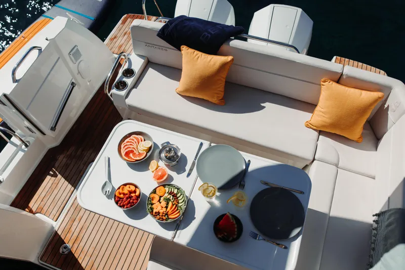 Slide: The Image of Luxurious 2027 Beneteau Antares 9 V2 yacht with elegant dining setup and vibrant cushions. - 9