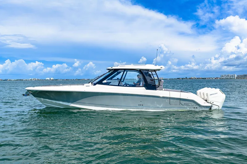 Slide: The Image of A 2026 Boston Whaler 380 Realm on calm waters under a blue sky. - 0