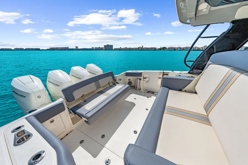 Slide: The Image of The image shows the stern of a 2026 Boston Whaler 380 Realm with luxurious seating and four engines. - 43