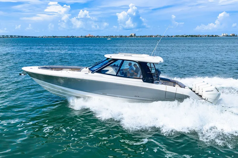 Slide: The Image of A 2026 Boston Whaler 380 Realm speeds across the water under a blue sky. - 36