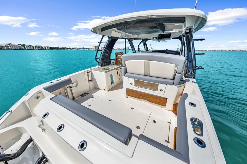 Slide: The Image of The image shows a modern boat with a spacious deck and luxurious seating on turquoise water. - 40