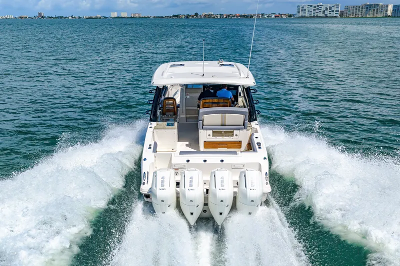 Slide: The Image of Boston Whaler 380 Realm from 2026 speeding on open water with four outboard engines. - 34