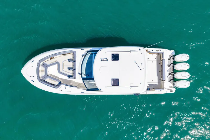 Slide: The Image of Aerial view of a 2026 Boston Whaler 380 Realm on turquoise water with four outboard engines. - 5