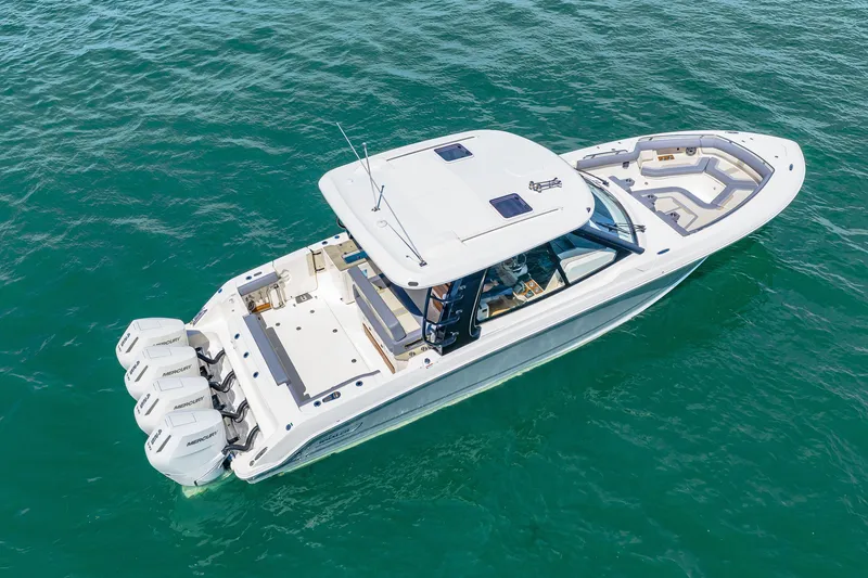 Slide: The Image of 2026 Boston Whaler 380 Realm on calm water, featuring four outboard engines and a spacious deck. - 21