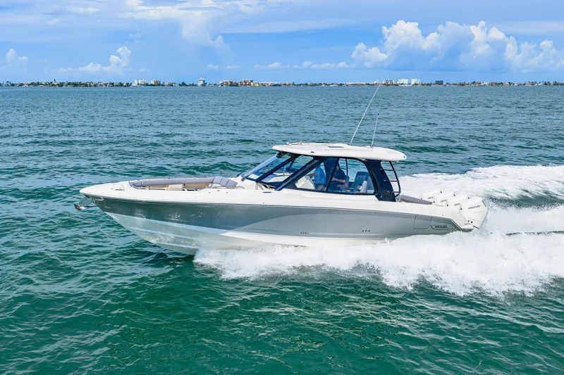 Slide: The Image of Boston Whaler 380 Realm from 2026 cruising swiftly on open water under a blue sky. - 23