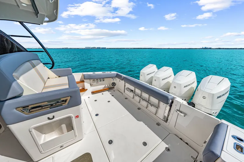Slide: The Image of The image shows the stern of a Boston Whaler 380 Realm with four outboard engines on calm water. - 42