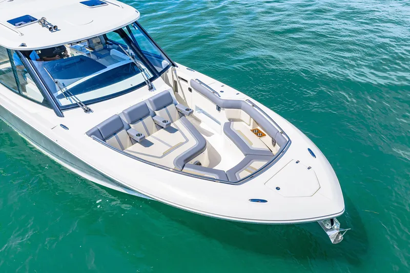 Slide: The Image of The image shows a sleek boat with white and gray seating on turquoise water. - 18