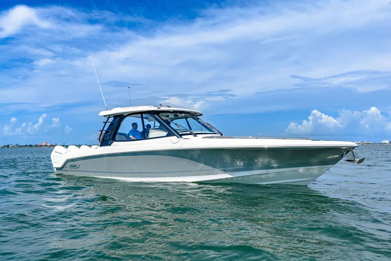 Slide: The Image of The 2026 Boston Whaler 380 Realm glides on calm waters under a clear blue sky. - 15