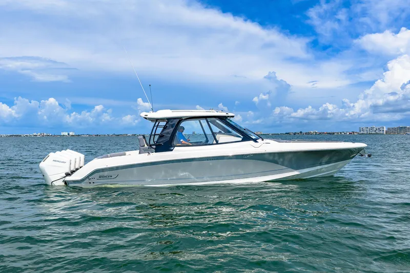 Slide: The Image of A sleek 2026 Boston Whaler 380 Realm boat on calm waters under a blue sky. - 14