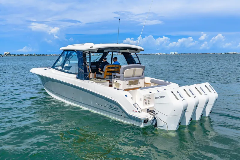 Slide: The Image of A 2026 Boston Whaler 380 Realm on calm water with four outboard engines. - 8