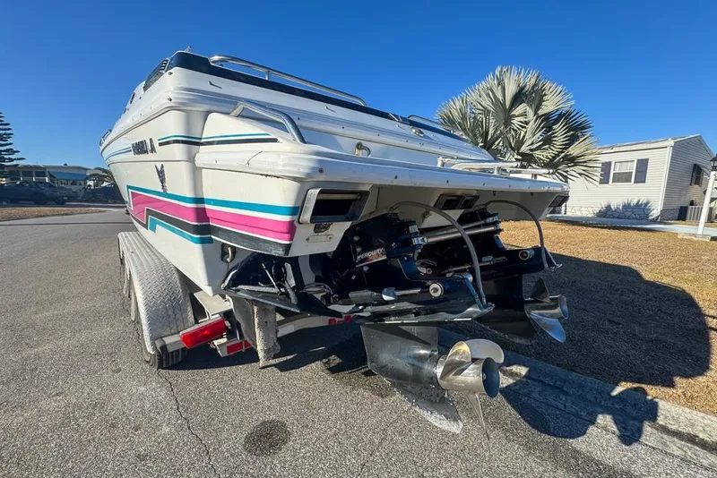 Slide: The Image of 1989 Formula 292 SR-1 boat on trailer, showcasing dual propellers and vibrant stripes. - 12