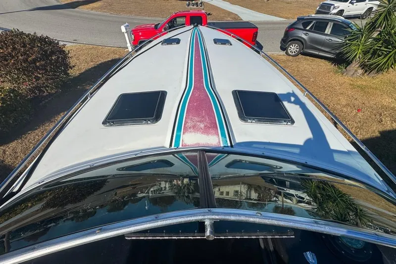 Slide: The Image of 1989 Formula 292 SR-1 boat with colorful stripes, parked near vehicles and greenery. - 38