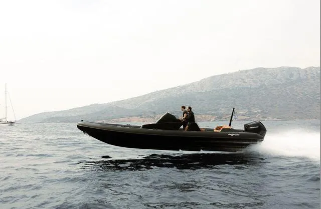 Slide: The Image of Roughneck RIB 1010 boat cruising on water, 2022 model, with mountainous background. - 16