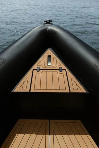 Slide: The Image of Roughneck RIB 1010 boat, 2022 model, featuring a sleek black and wood design on water. - 19
