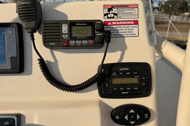 Slide: The Image of Control panel of a 2015 Cobia 201 Center Console boat with radio and warning labels. - 12