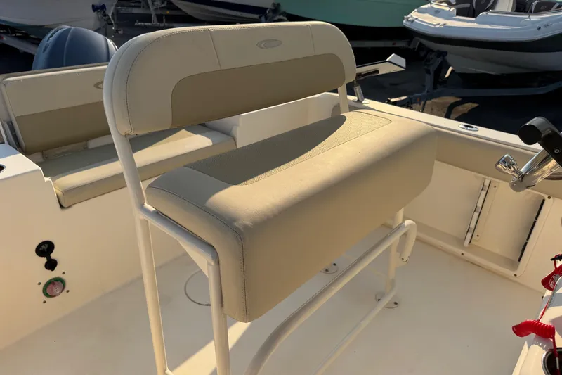 Slide: The Image of 2015 Cobia 201 Center Console boat interior with beige seating and control panel. - 17