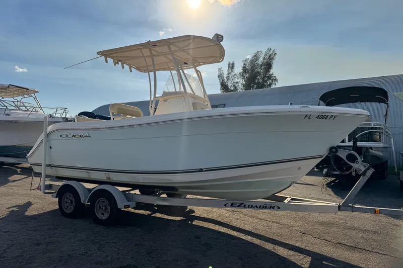 Slide: The Image of 2015 Cobia 201 Center Console boat on trailer under sunny sky. - 2