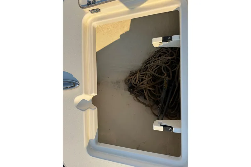 Slide: The Image of Storage compartment with rope on a 2015 Cobia 201 Center Console boat. - 21