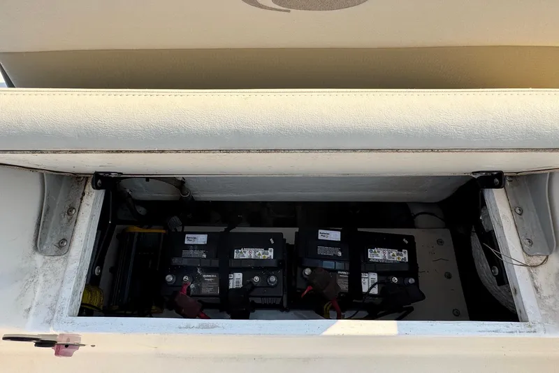 Slide: The Image of 2015 Cobia 201 Center Console boat battery compartment with multiple batteries visible. - 28