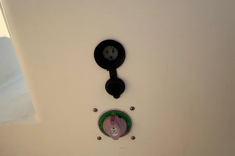 Slide: The Image of 2015 Cobia 201 Center Console boat control panel with power switch and outlet. - 29