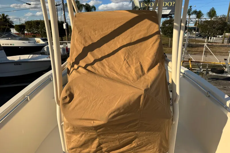 Slide: The Image of 2015 Cobia 201 Center Console boat with covered seating, parked outdoors. - 36