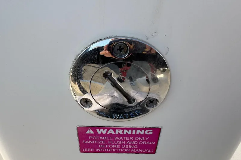 Slide: The Image of Potable water access on 2015 Cobia 201 Center Console with warning label. - 37