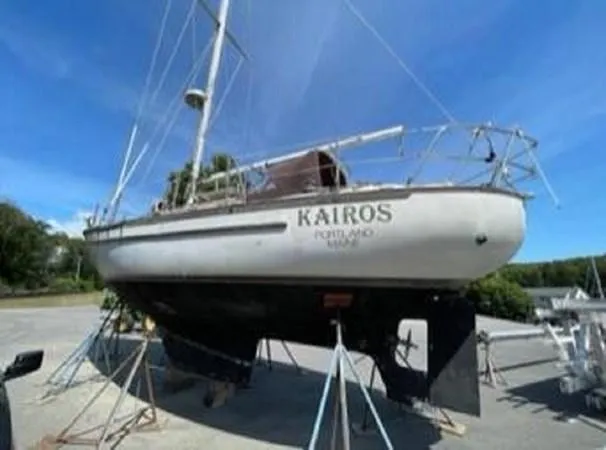 The Image of 1986 Pacific Seacraft 34 sailboat "Kairos" on stands, clear sky background. - 0