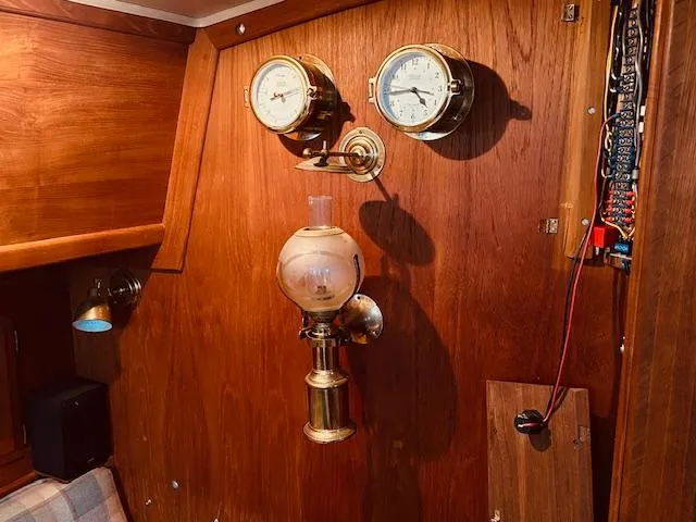 Slide: The Image of Interior of 1986 Pacific Seacraft 34 with brass gauges and vintage lamp on wooden panel. - 10