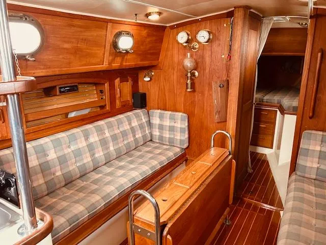 Slide: The Image of Interior of 1986 Pacific Seacraft 34 sailboat with wood paneling and plaid seating. - 2