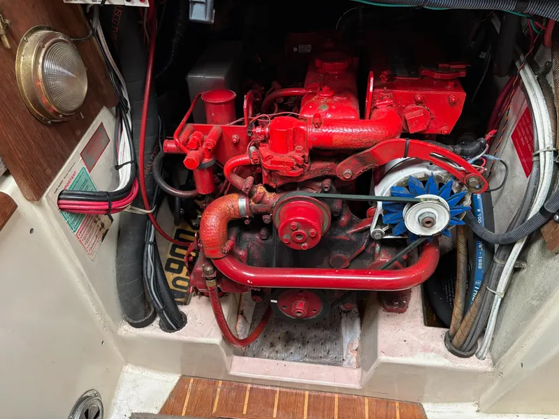 Slide: The Image of Engine compartment of a 1986 Pacific Seacraft 34 sailboat, featuring a red-painted engine. - 22