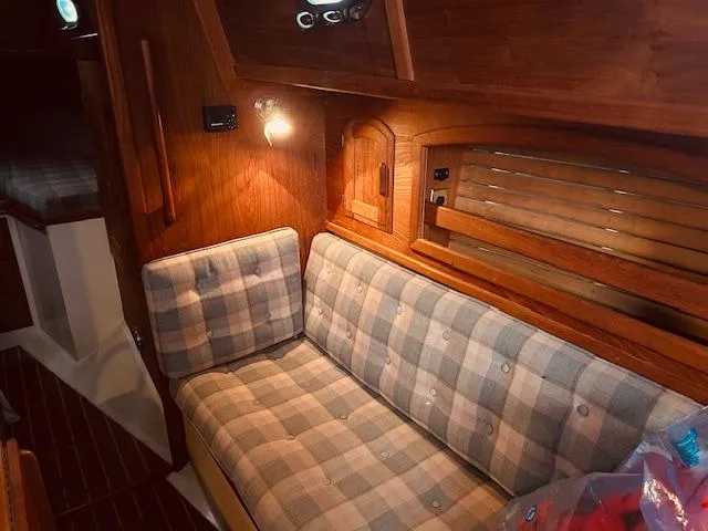 Slide: The Image of 1986 Pacific Seacraft 34 interior with plaid seating and wooden accents. - 5