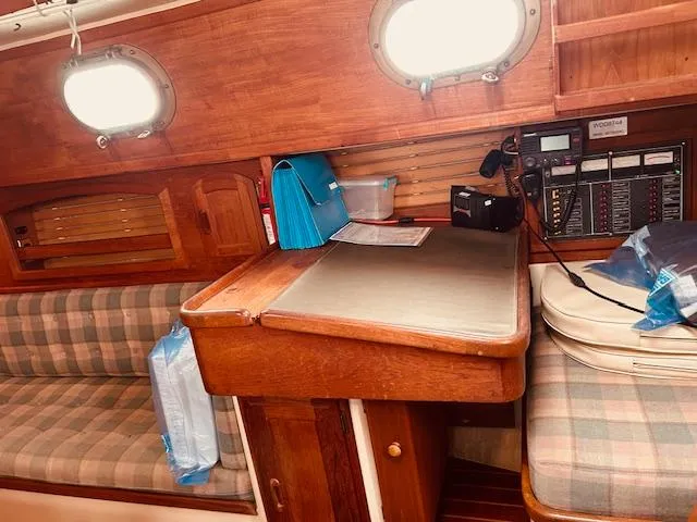 Slide: The Image of 1986 Pacific Seacraft 34 interior with navigation station and plaid seating. - 6