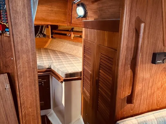 Slide: The Image of Interior of 1986 Pacific Seacraft 34 sailboat with wooden cabinetry and cozy sleeping area. - 7