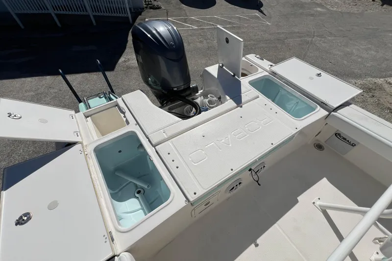 Slide: The Image of 2024 Robalo 226 Cayman boat deck with storage compartments and outboard motor. - 10