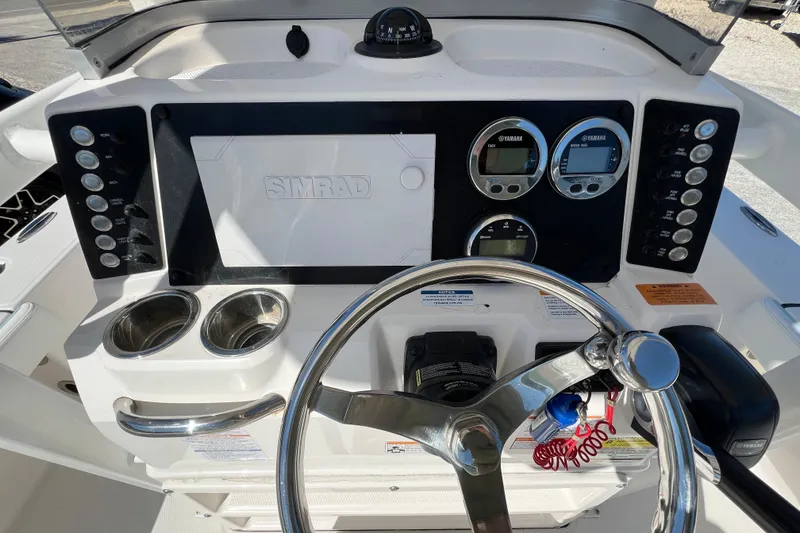 Slide: The Image of 2024 Robalo 226 Cayman boat dashboard with Simrad display and Yamaha gauges. - 14