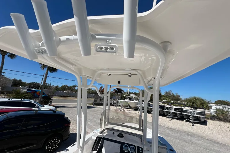 Slide: The Image of 2024 Robalo 226 Cayman boat with T-top and rod holders, parked outdoors. - 15