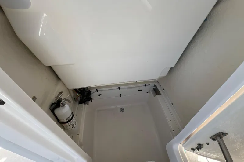 Slide: The Image of 2024 Robalo 226 Cayman storage compartment with fire extinguisher, showcasing interior details. - 18