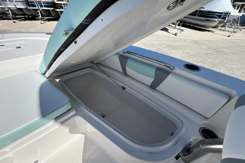 Slide: The Image of 2024 Robalo 226 Cayman boat storage compartment open, showcasing spacious interior design. - 19