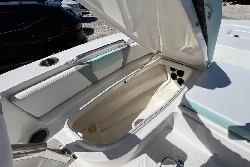 Slide: The Image of 2024 Robalo 226 Cayman boat storage compartment with open lid and seating area. - 20