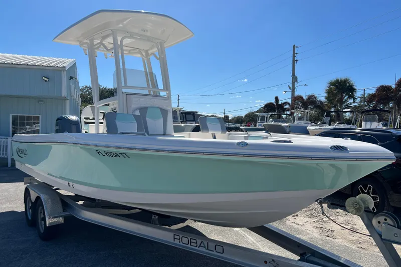 Slide: The Image of 2024 Robalo 226 Cayman boat on trailer, light blue hull, sunny day. - 3