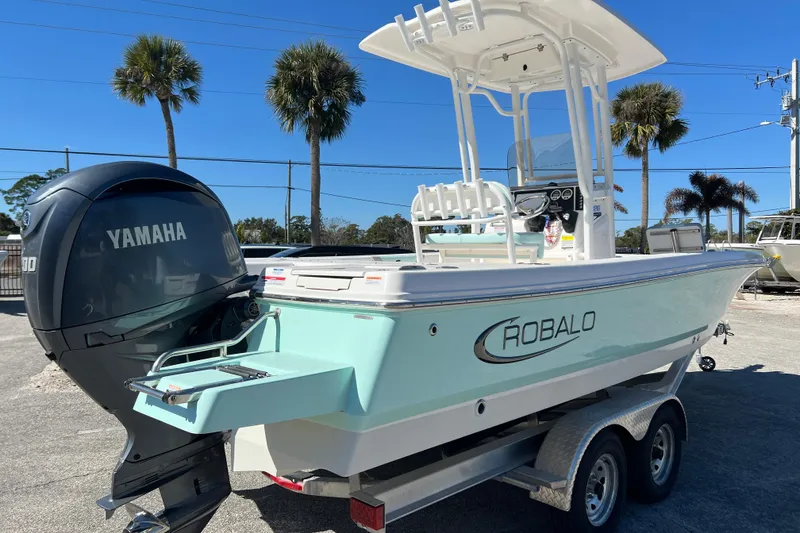 Slide: The Image of 2024 Robalo 226 Cayman boat with Yamaha engine on trailer, palm trees in background. - 5