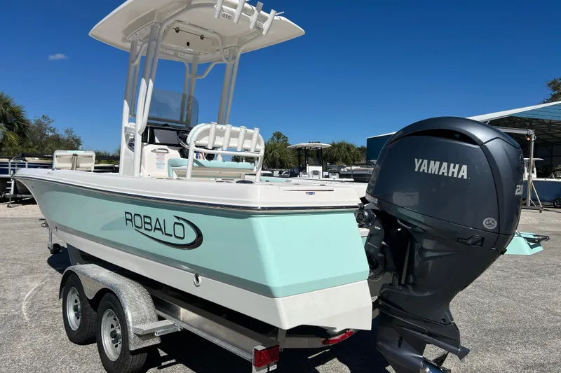 Slide: The Image of 2024 Robalo 226 Cayman boat with Yamaha engine on trailer, under clear blue sky. - 7
