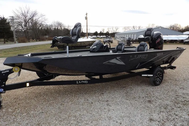 The Image of 2026 Lund 1875 Renegade boat on trailer, parked outdoors, showcasing sleek design. - 1