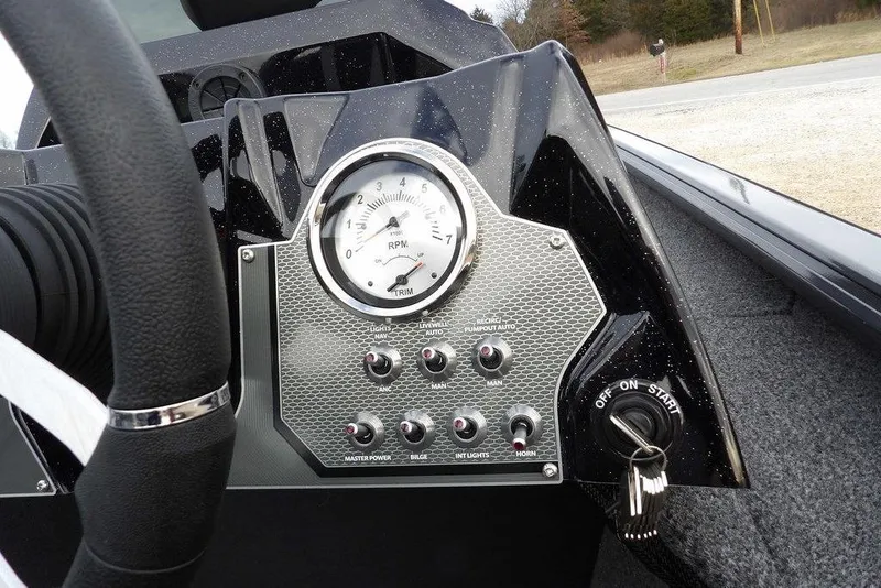 Slide: The Image of Dashboard of 2026 Lund 1875 Renegade boat with RPM gauge and control switches. - 27