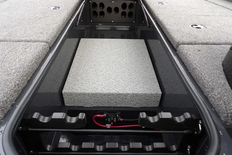 Slide: The Image of 2026 Lund 1875 Renegade boat interior with storage compartments and carpeted flooring. - 31